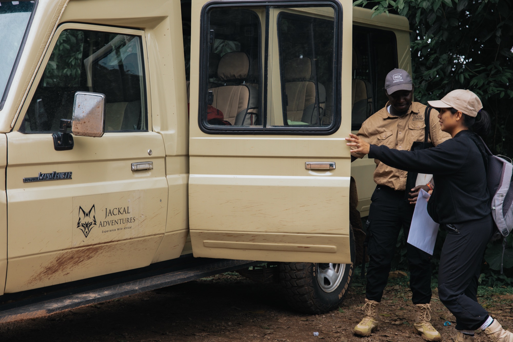 A Jackal Adventures Africa safari guide helps a traveller into the company's own Land Cruiser